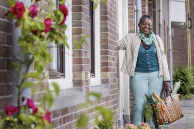 Vrouw loopt naar buiten met boodschappentas